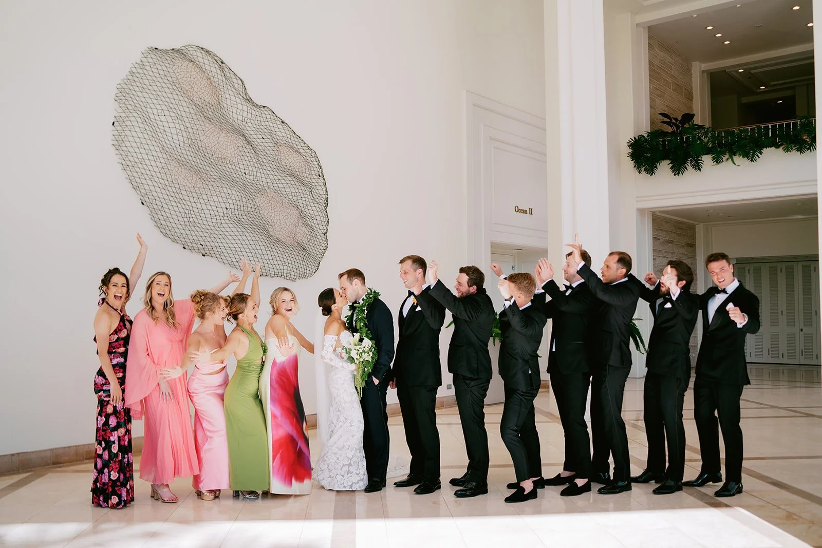 wedding party cheering as bride and groom kiss