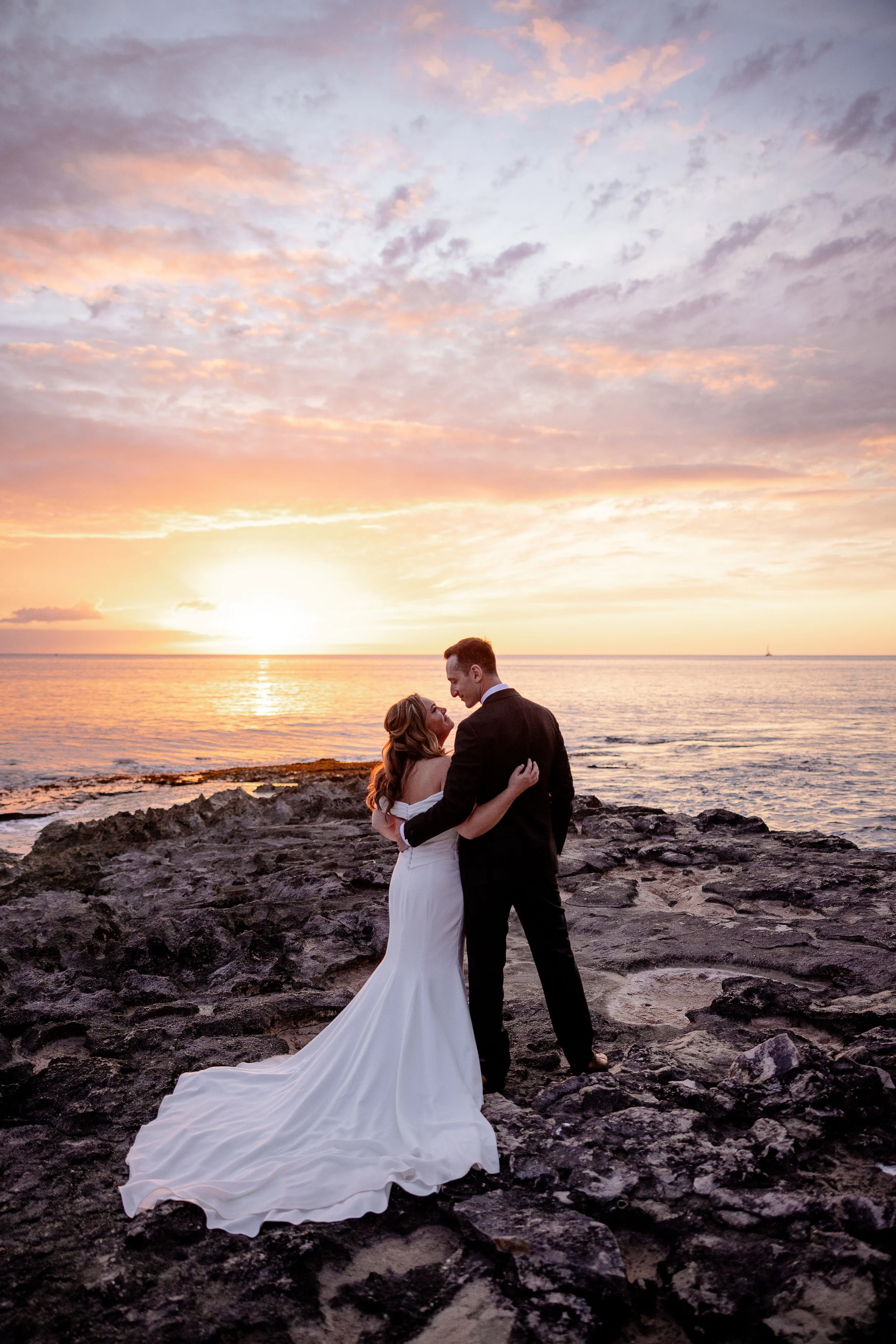 bride and groom on a beach in Hawai'i at sunset