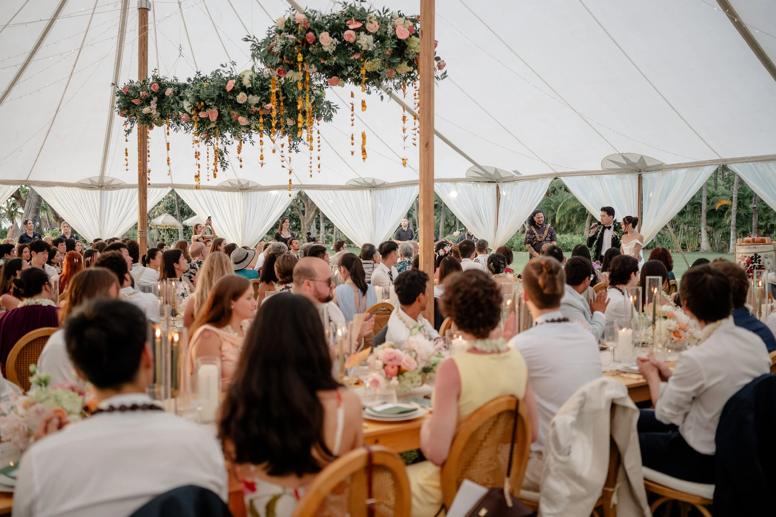 guests seated for dinner as newly wed couple makes a welcome speech