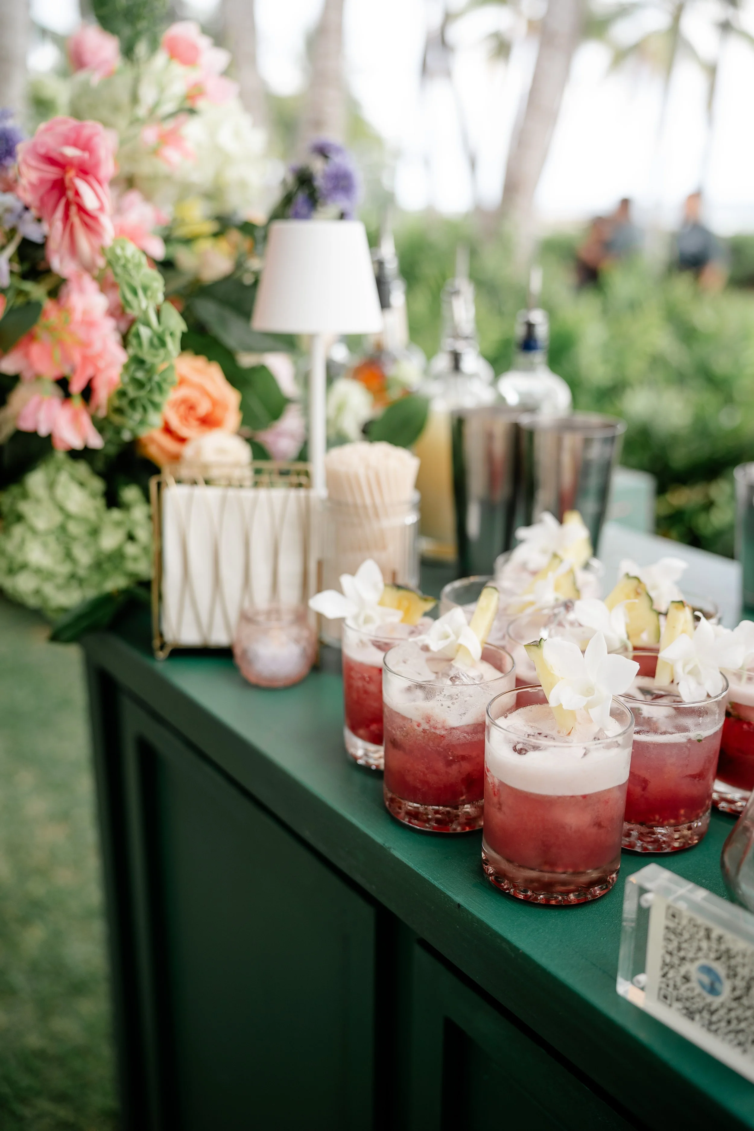 specialty drinks lined up in a group on top of bar