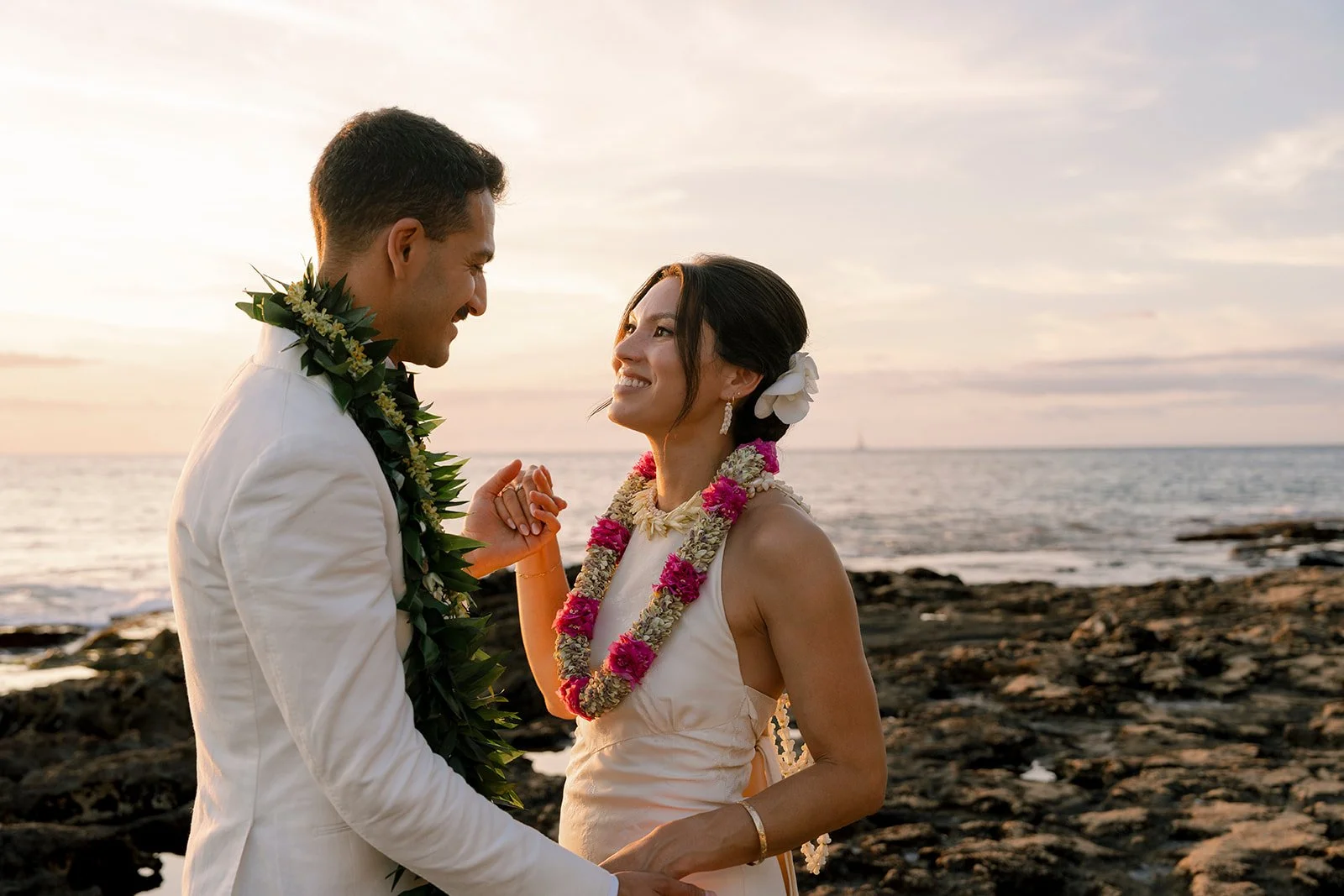 bride and groom looking at each other on beach in hawaii