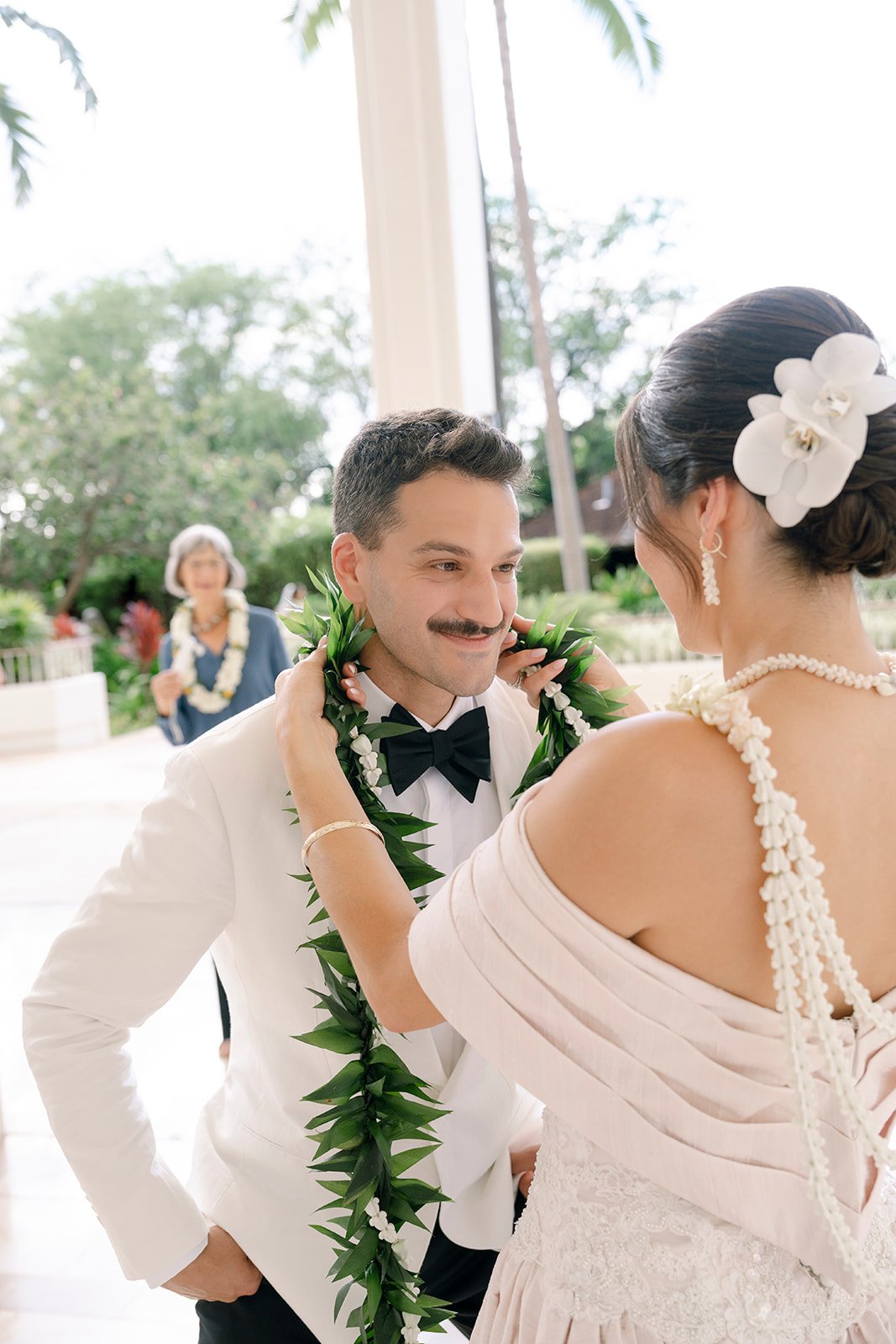 bride putting lei on groom