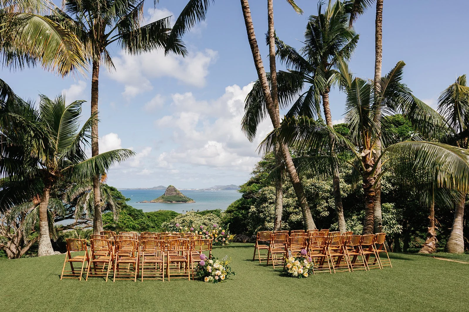 Ceremony chairs with flower arrangements at Paliku Gardens
