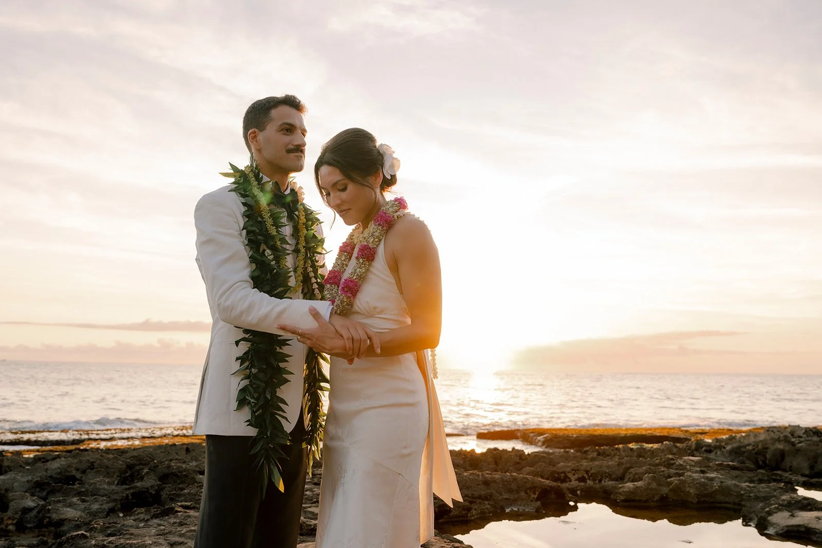 bride and groom on the beach during sunset in hawaii