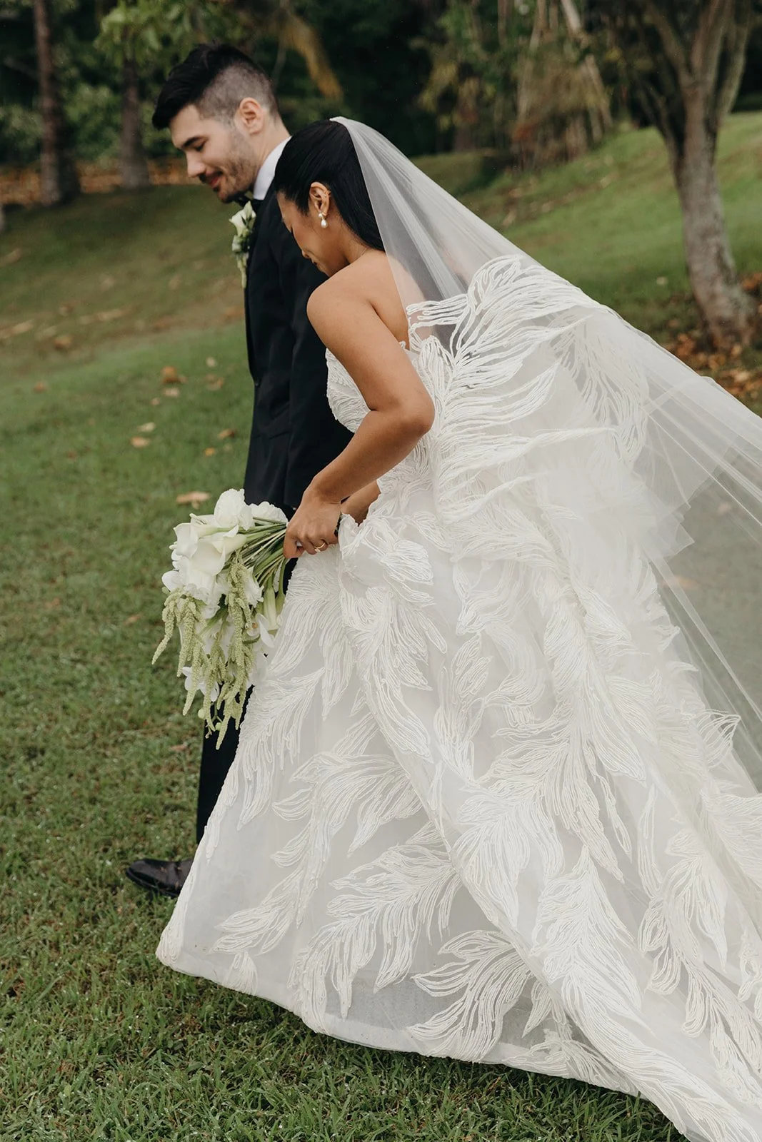 bride and groom walking with flower bouquet