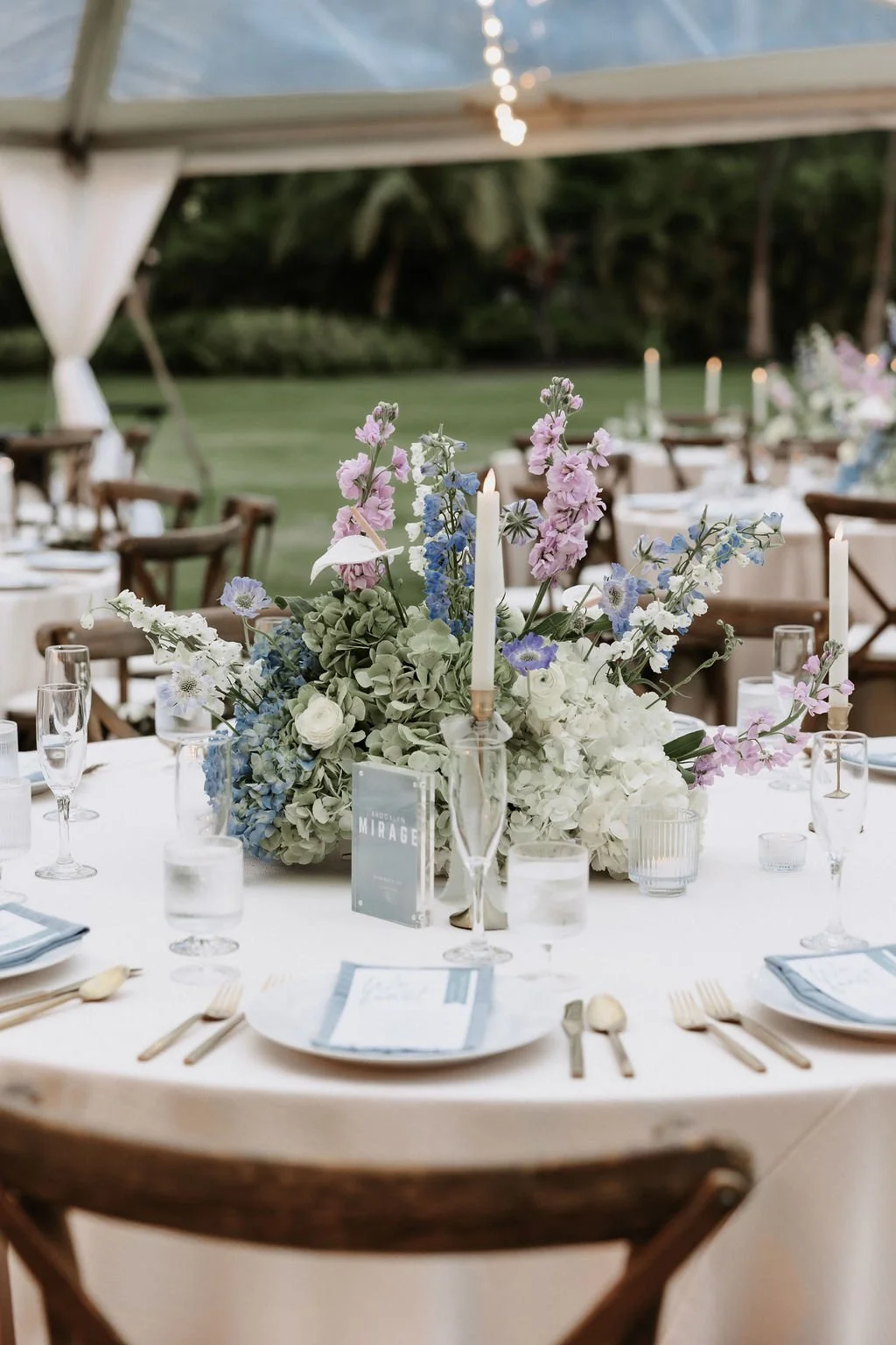 Wedding reception round table styled with taper candles and round flower centerpiece.