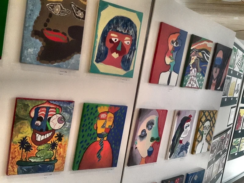 Artwork lining both sides of the main room in our library, leading students and staff to the book display 