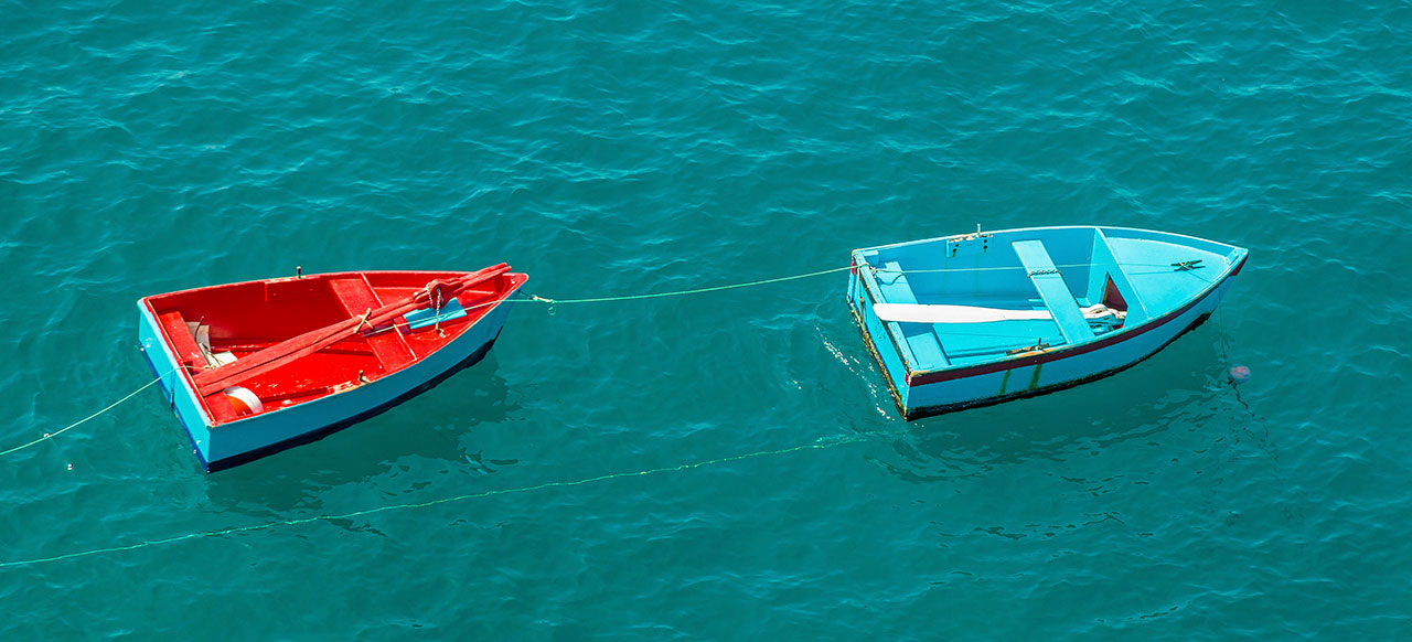 Image of one row boat pulling another row boat
