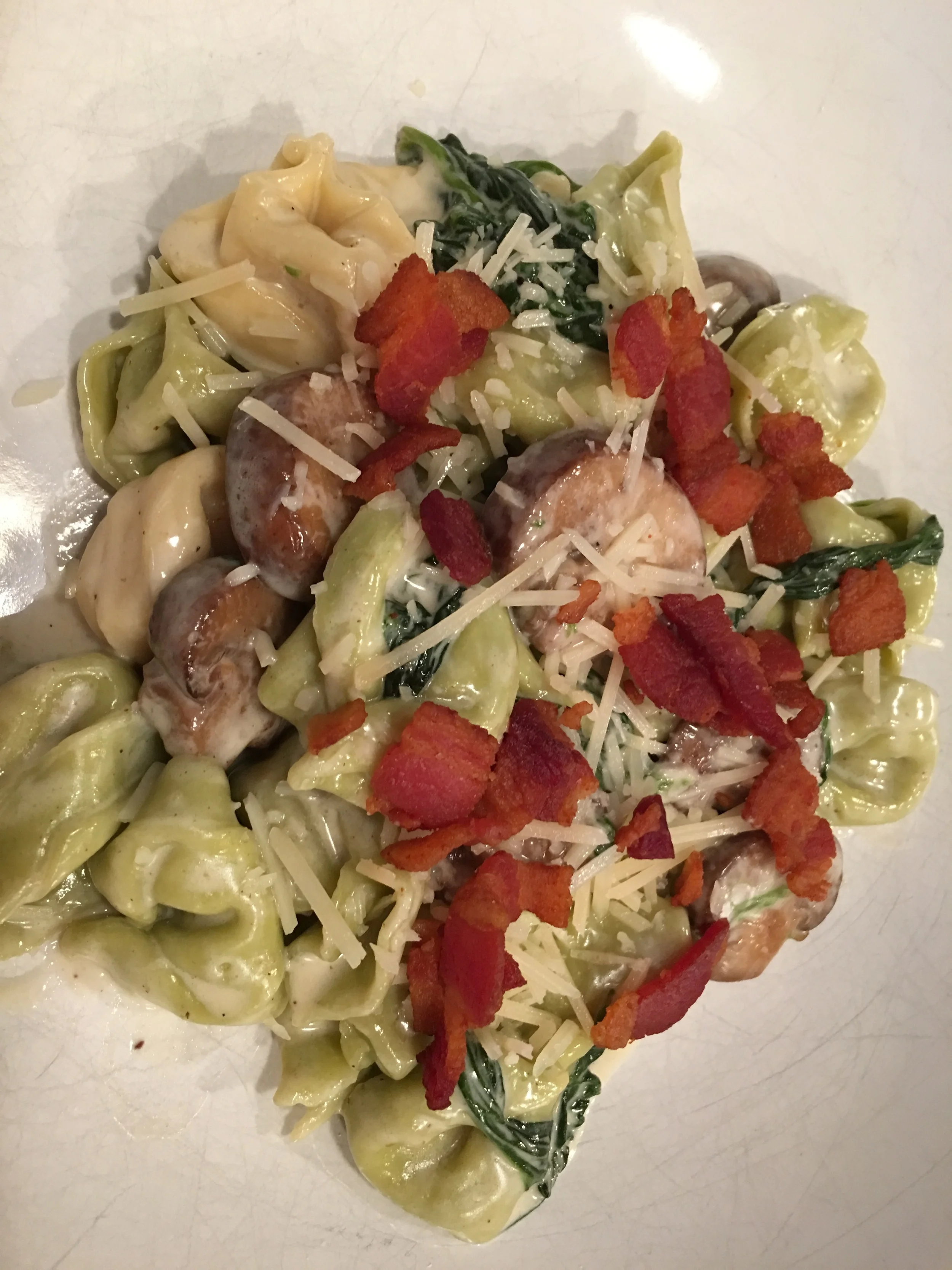 Cheese tortellini with spinach, cremini mushrooms, and bacon crumbles