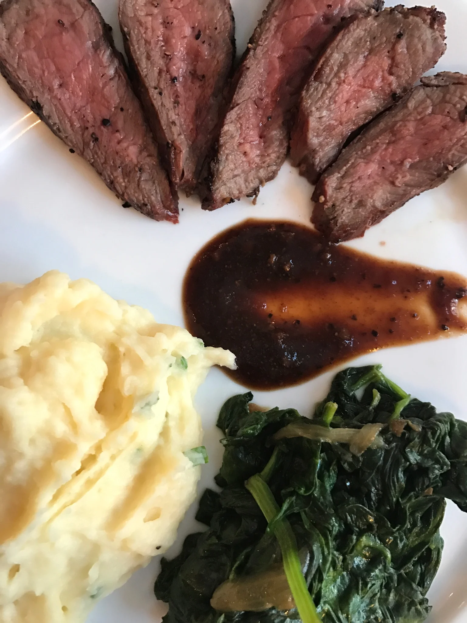 Sliced sirloin with cheddar mashed potatoes and sautéed spinach