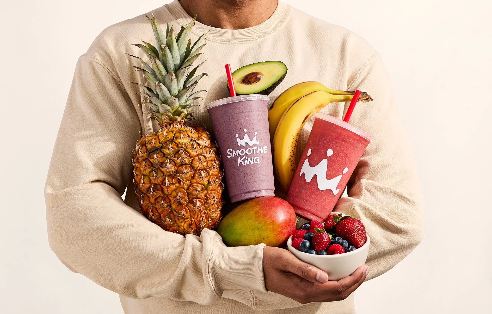 Man holding 2 Smoothie King drinks with fruits like pineapple, mango, banana, avocado and berries / Jennifer Chong  - Food, Beverage and Lifestyle Photographer