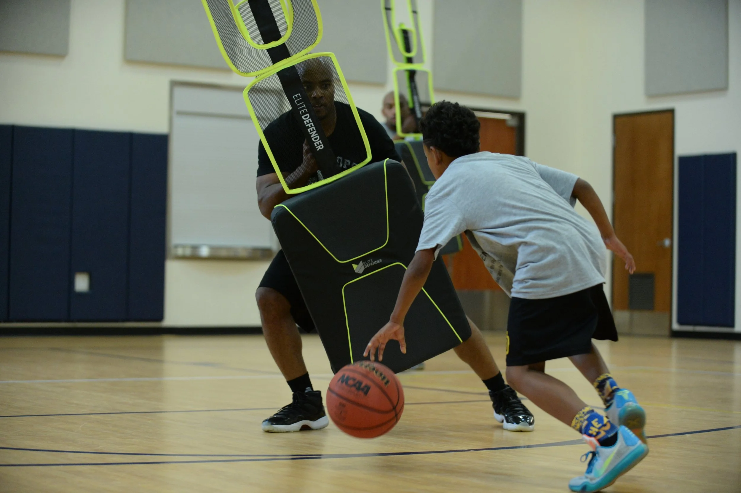 One basketball trainer using the Elite Defender to train a basketball player on ball handling skills.