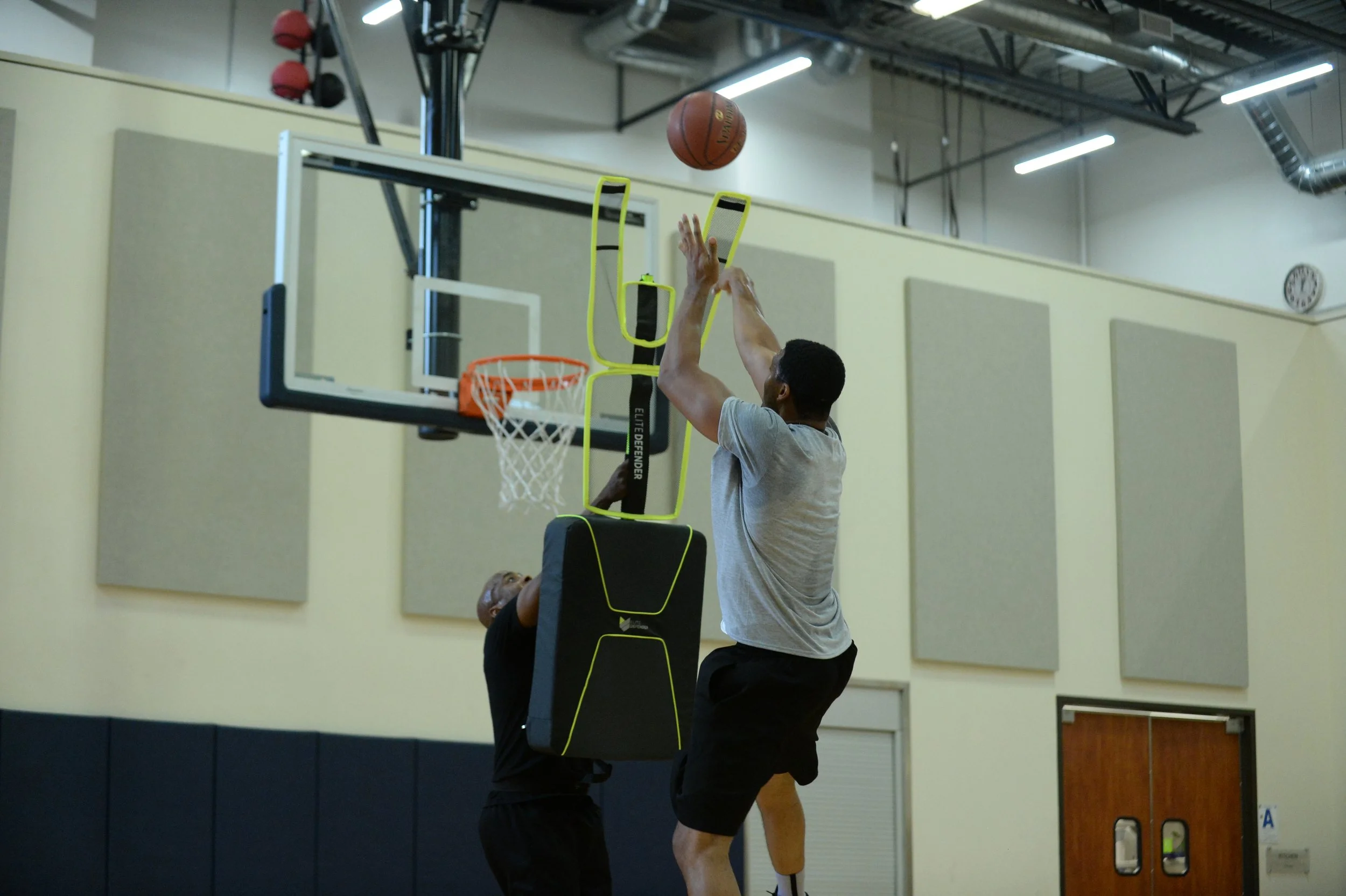 Two players using the Elite Defender for basketball training for jump shots.