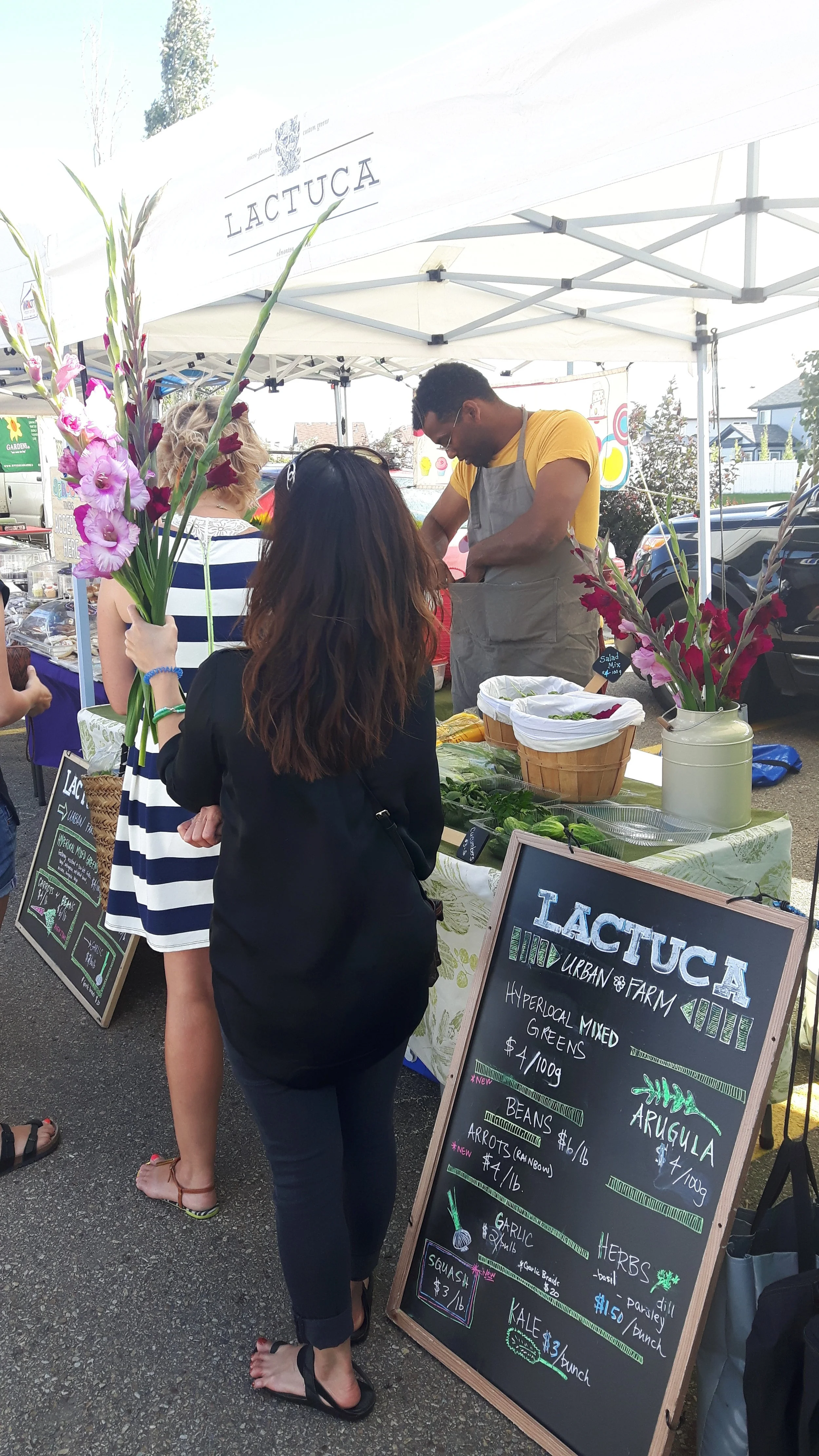 Our photo of the week features the happy crowd around Lactuca's stall stocking up on local veggies and beautiful cut flowers.