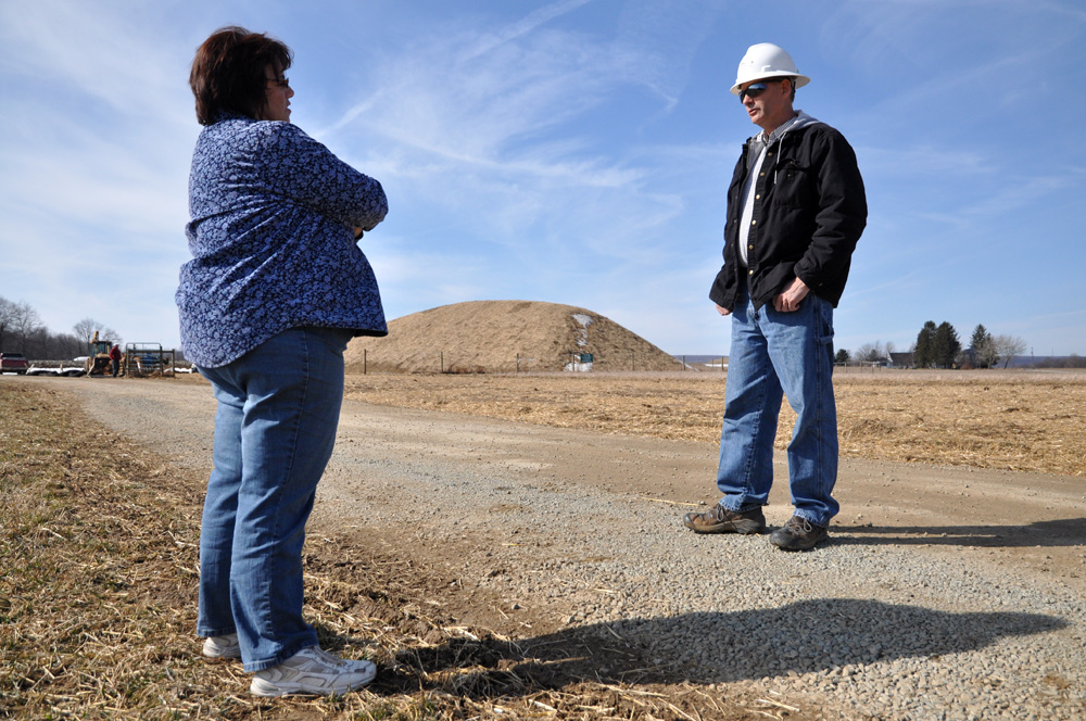  Janet Miller speaks with a worker near the well pad on the Millers’ property. Relations with the workers have been cordial, though unstable—workers come and go regularly, so it has been difficult to establish a long-term rapport.&nbsp;  ©    Brian C