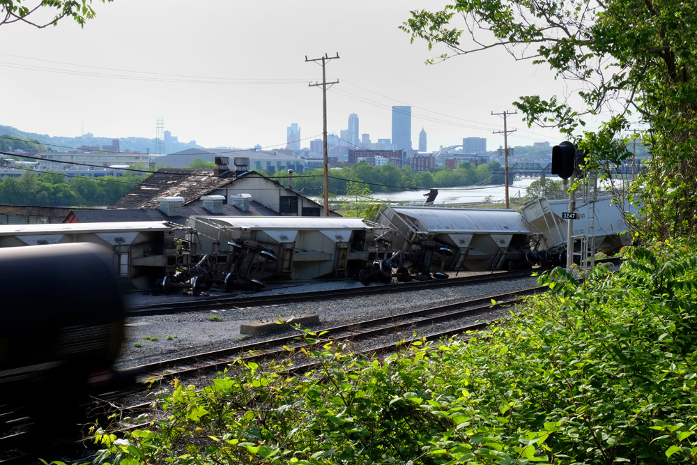  An oil car speeds past a derailed train in the Hazelwood neighborhood of Pittsburgh.&nbsp; Downtown Pittsburgh is less than three miles away.&nbsp; © Brian Cohen, 2015. 