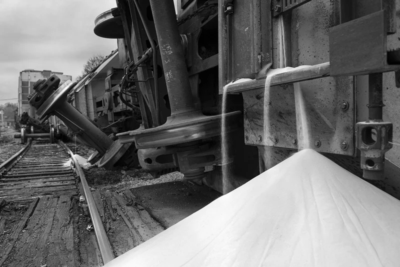A train derailment in Uniontown, PA in 2015. One car landed 6 feet from a nearby house, spilling frack sand around it. Frack sand is used during the hydraulic fracturing process and is hazardous to human health. The particulates are so small and oddly shaped that they seldom release from the lungs and can cause many respiratory problems including lung cancer. Sand was still pouring from the train cars two hours after the accident. Residents were not warned of potential respiratory problems and the workers who cleaned it up did not wear breathing protection. © Scott Goldsmith/TDW 2015