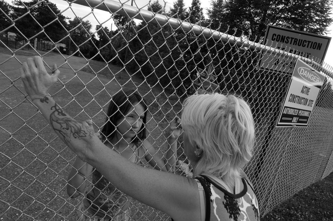  Activist Wendy Lynne Lee talks to Riverdale residentChevelle Eck through a chain-link fence constructedshortly after activists were led off the property.&nbsp; Riverdale trailer park residents were evicted to clear theway for a water extraction plan