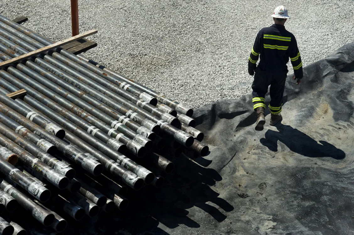 Pipe used in natural-gas drilling and a worker at Consol Energy's NV-31D rig in Morris Township, Washington County. © Martha Rial/MSDP 2012