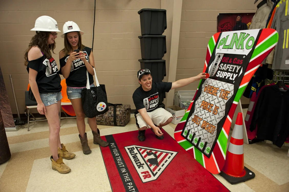 Volunteers take a break at the Oil and Gas Safety Supply booth at the Tri-County Oil & Gas Expo in the Washington County Fairgrounds. Oil & Gas Safety Supply sells affordable flame-resistant work wear. Amy Savage opened the store in Washington, PA and it's one of the growing number of women-owned businesses serving the gas, oil, and coal industry. © Martha Rial/MSDP 2012