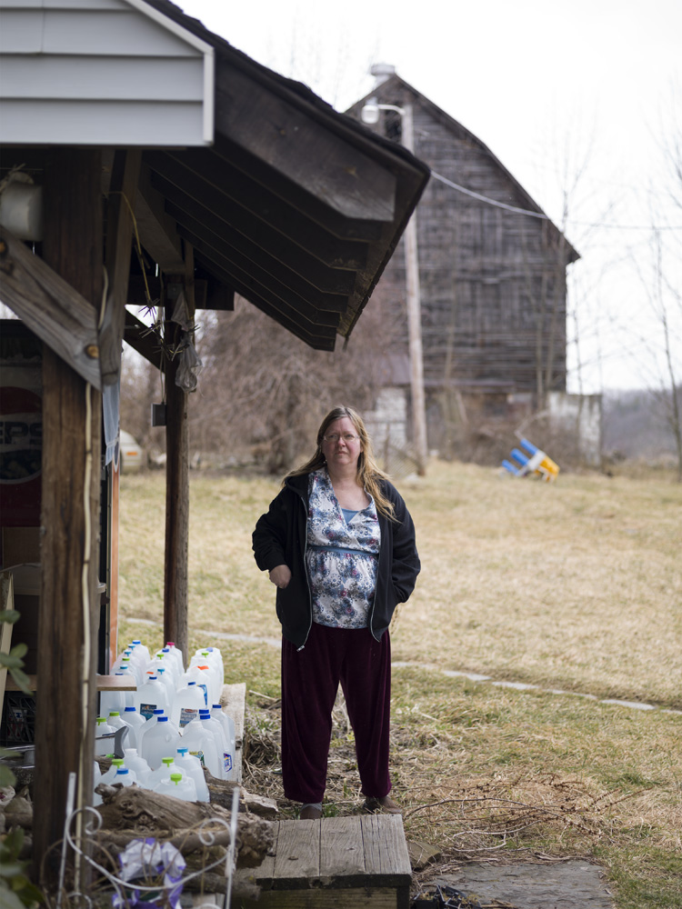  Pat Farnelli, outside her home that has lost most of its value after her well water went bad. She claims her well was contaminated by nearby Cabot Oil and Gas gas-drilling activities. Dimock, Susquehanna County, 2012.&nbsp; ©  &nbsp;Nina Berman/MSDP