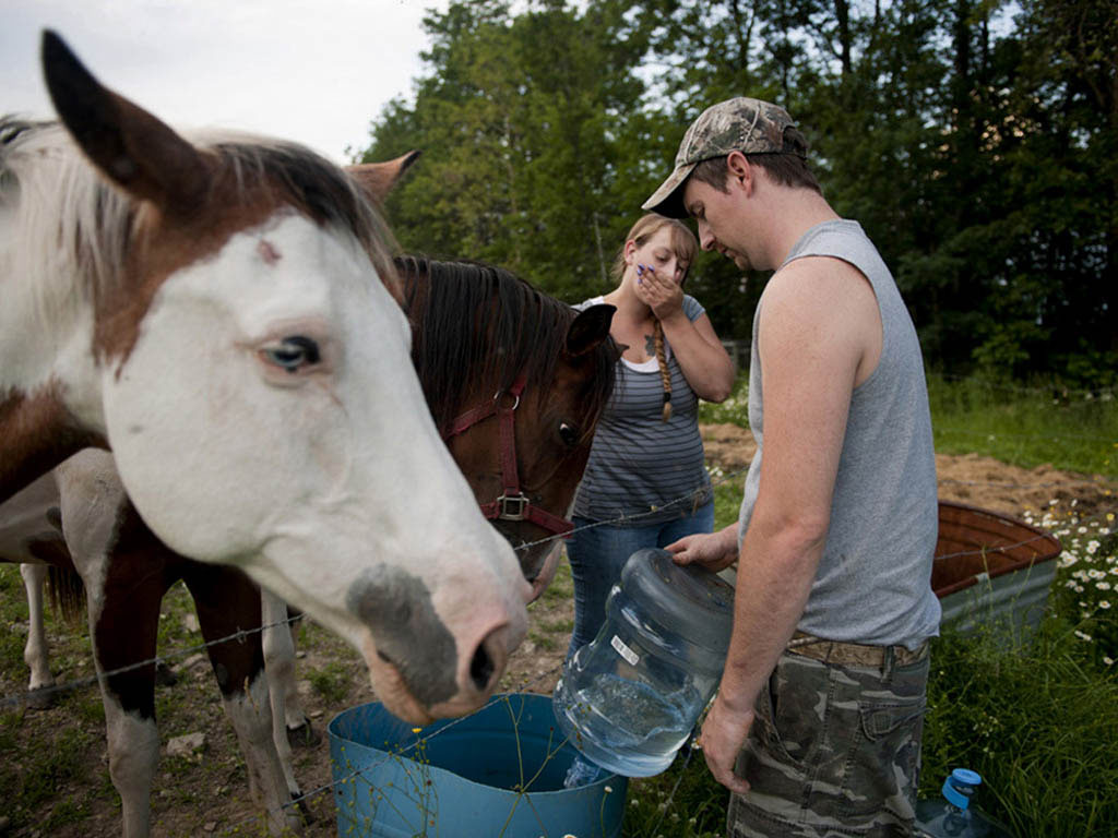  Having no clean well water, Simons and Lamphere give their horses bottled water to drink. They claim their water was contaminated by nearby gas-drilling activities causing their daughter to be sick and their animals to die. Monroeton, Bradford Count