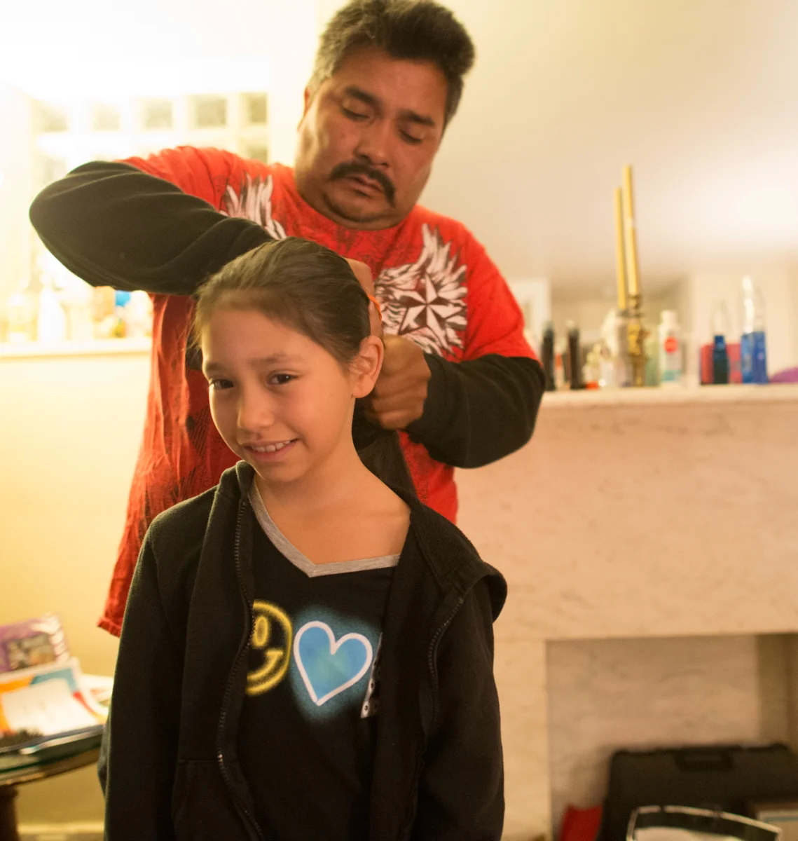Jose helps Emma with her hair before she heads off to school. © Nate Guidry/TDW 2017