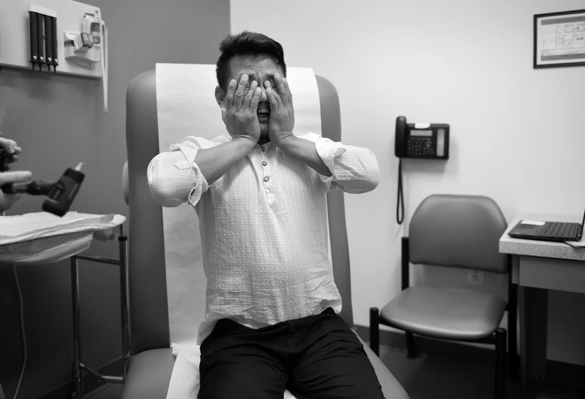 Som Raj Rai, making his first visit to an American doctor at the Squirrel Hill Health Center (SHHC) in the Brentwood neighborhood of Pittsburgh on June 9, 2017. The patients and staff of the SHHC collectively speak more than sixty different languages. Staff members realize that language barriers could sometimes result in lower-quality medical care, so when an interpreter is not available, they will use a telephone interpreting service in an effort to provide the best possible care. This family spoke via an interpreter by phone. © Scott Goldsmith/TDW 2017