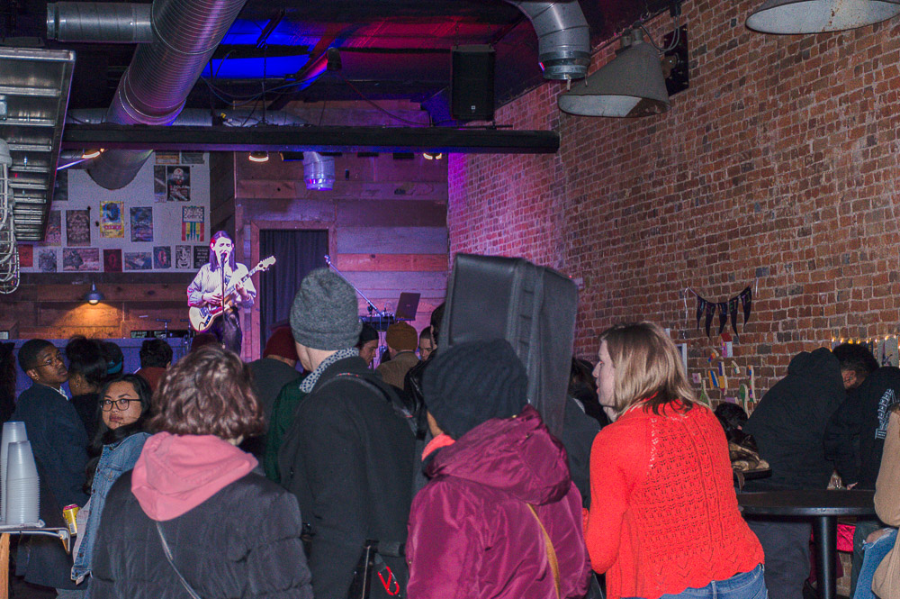  Crowd gathering around the multimedia artists at Andy’s bar, enjoying music, drinks and art. 