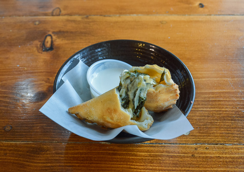  Spinach, goat cheese &amp; caramelized onion empanada with garlic crema. 