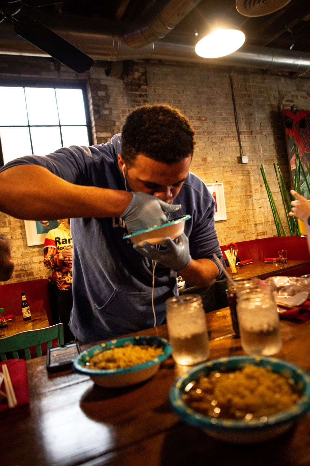  Alaric Ukeh, representing Lucky Lou’s, dons medical gloves and earbuds as he digs in for the ramen eating competition. 