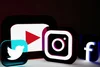 Illuminated social media icons including YouTube, Twitter, Instagram, and Facebook displayed on a dark background.