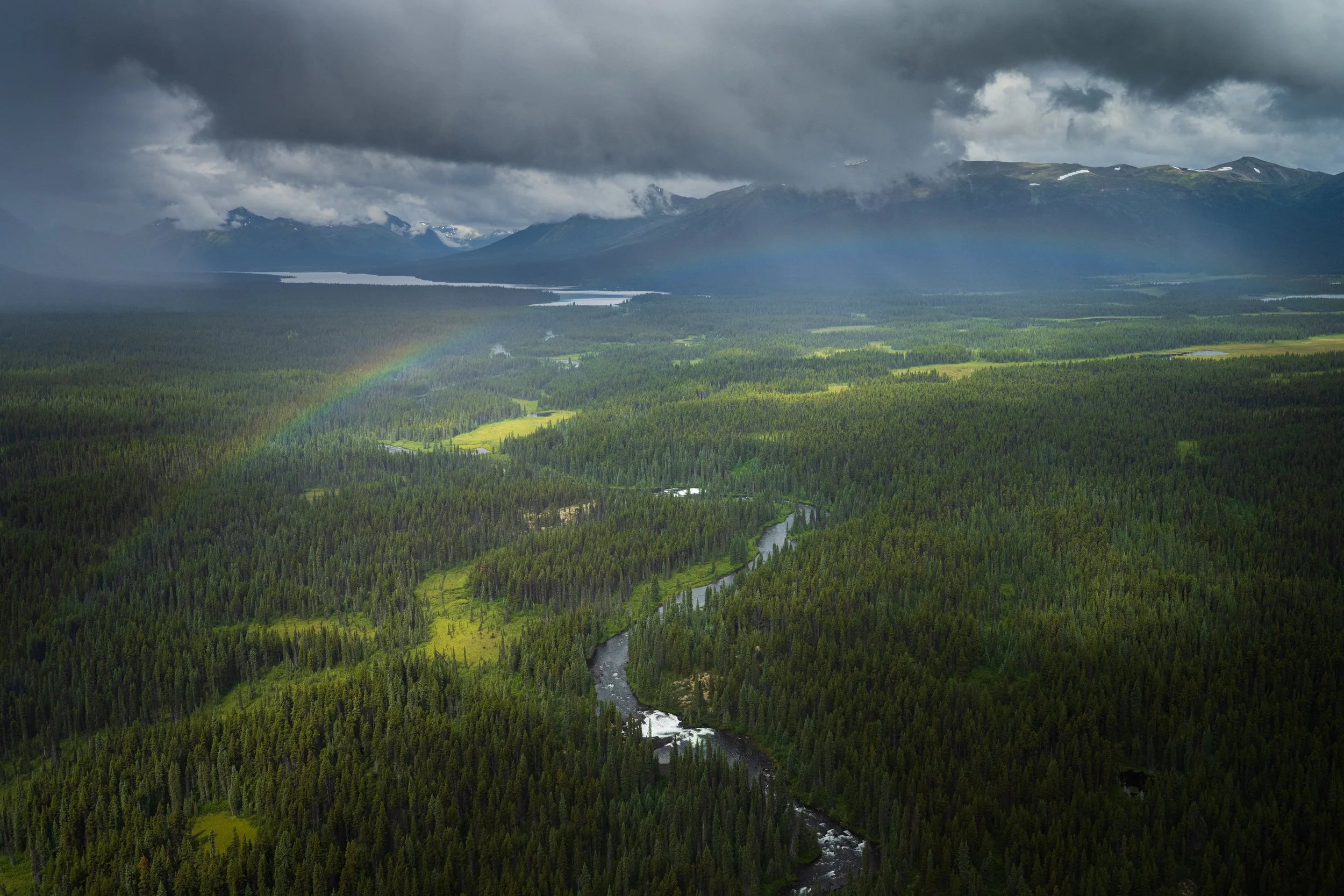 Aerial capture of a rainbow over the waters of Rognaas Creek, outflowing from Kitchener Lake in Tatlatui Provincial Park