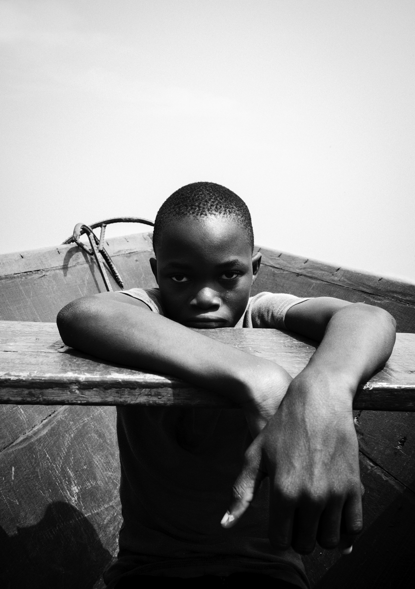  11-year-old Joseph is sitting in his father's wooden canoe near Ada Foah, Southern Ghana. This water taxi carries locals commuting between the many small villages located on the Volta River estuary.⁠ 