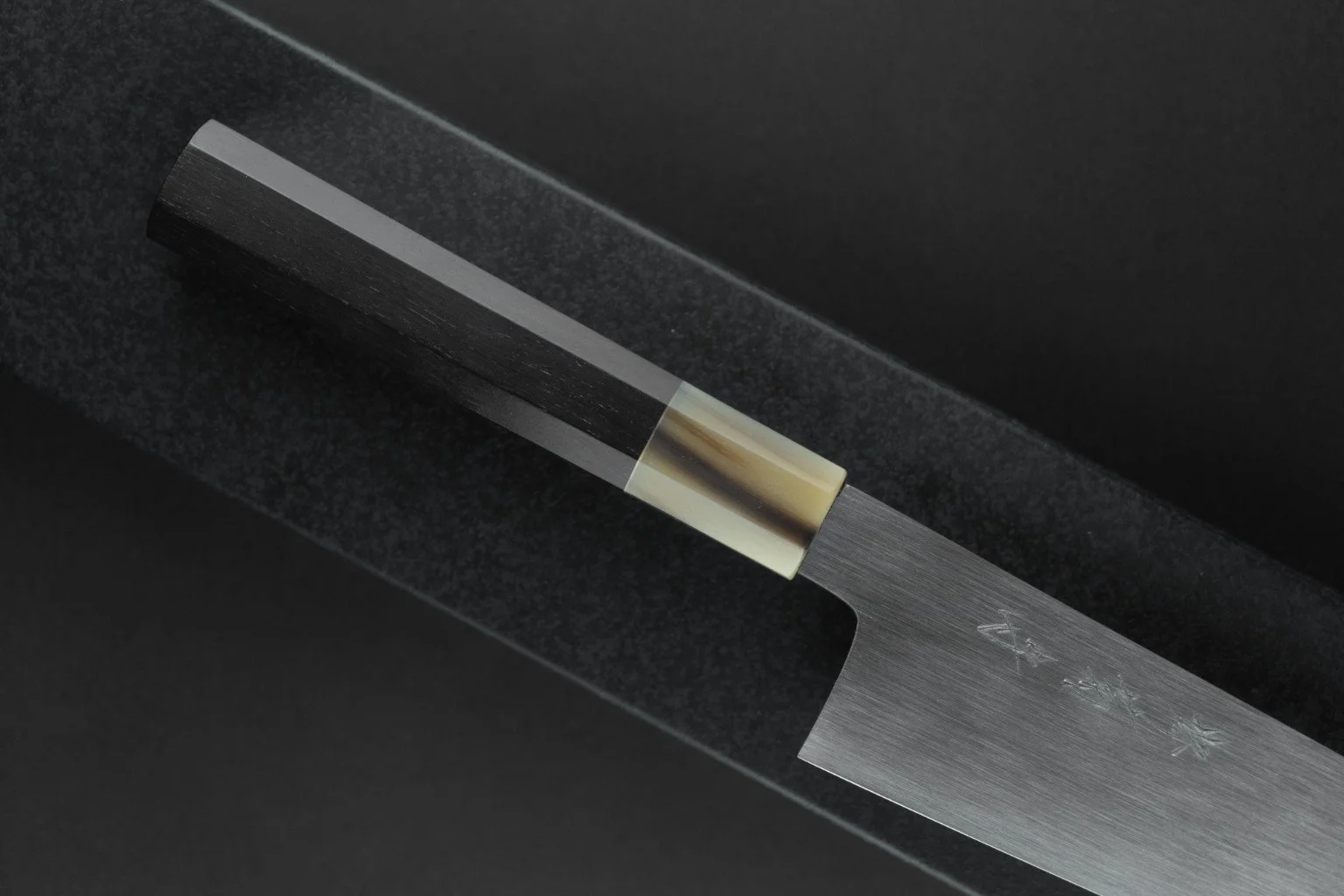 Détail du manche octogonal en ébène et corne de buffle blonde du Tokuseï Kikumori Suminagashi Gyuto 210 mm.