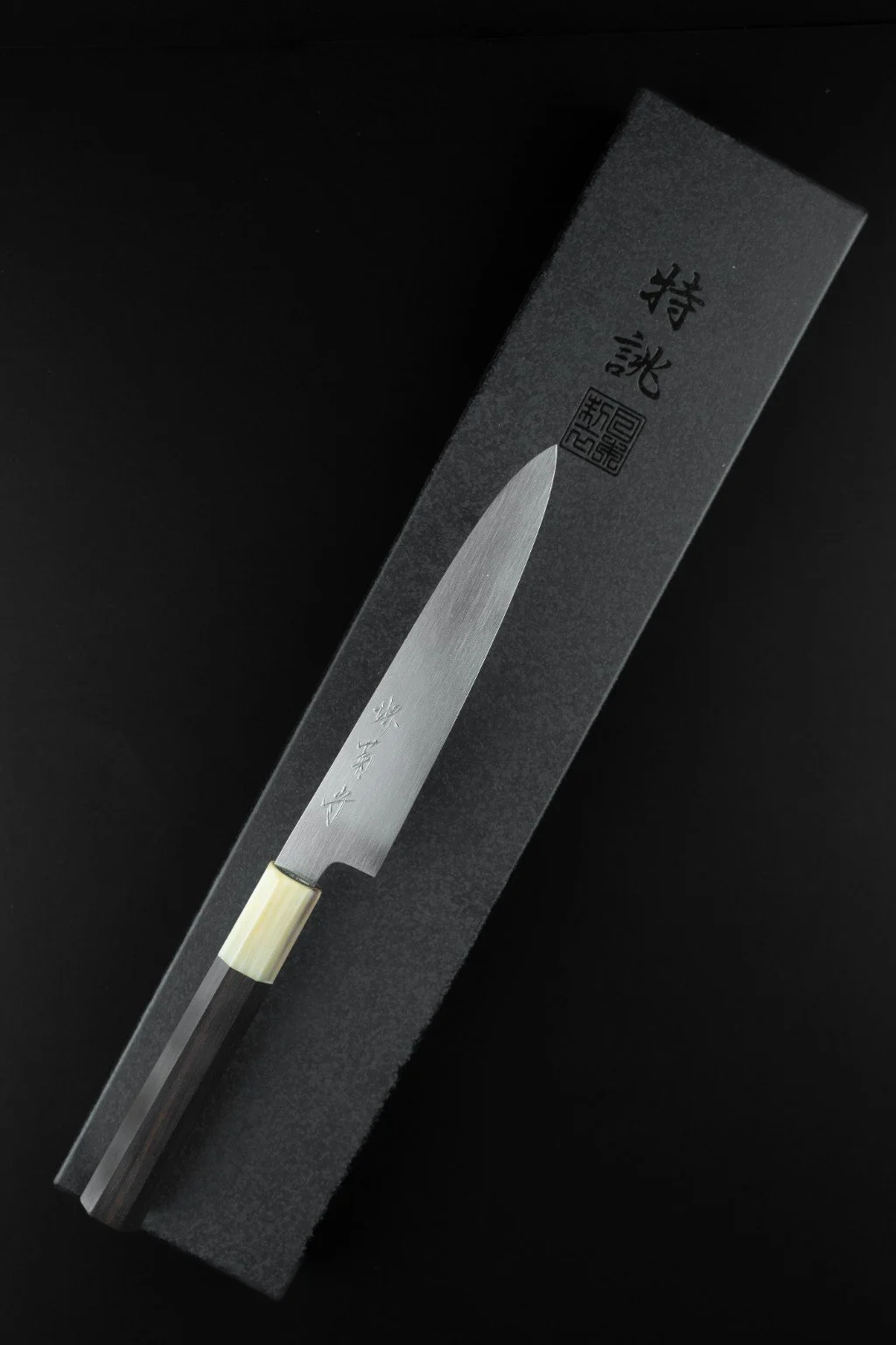 Couteau japonais Tokuseï Kikumori Suminagashi Petty 135 mm, vue d’ensemble avec manche octogonal en ébène et corne de buffle blonde.