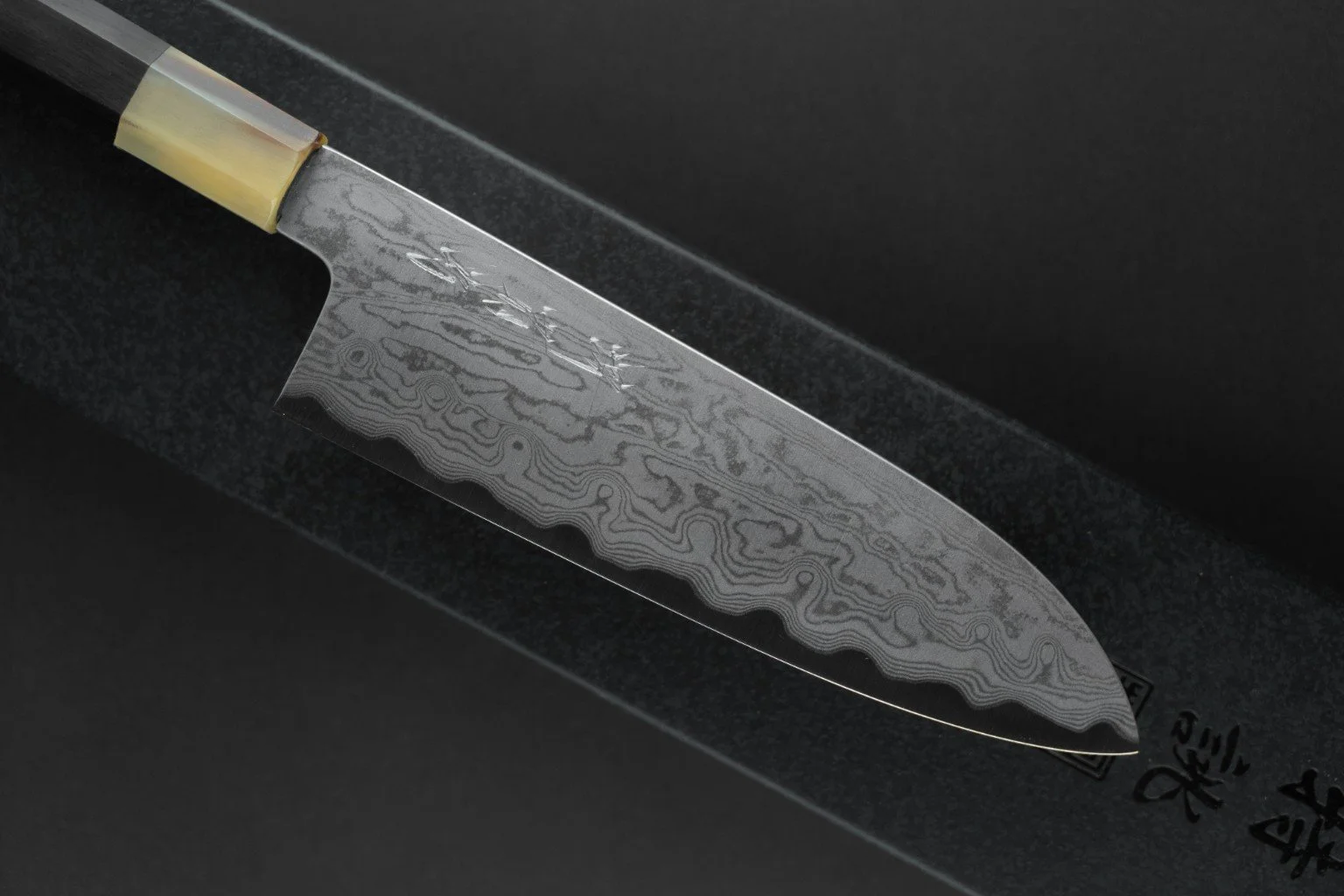 Détail de la lame damassée et de la gravure du Tokuseï Kikumori Suminagashi Santoku 165 mm.