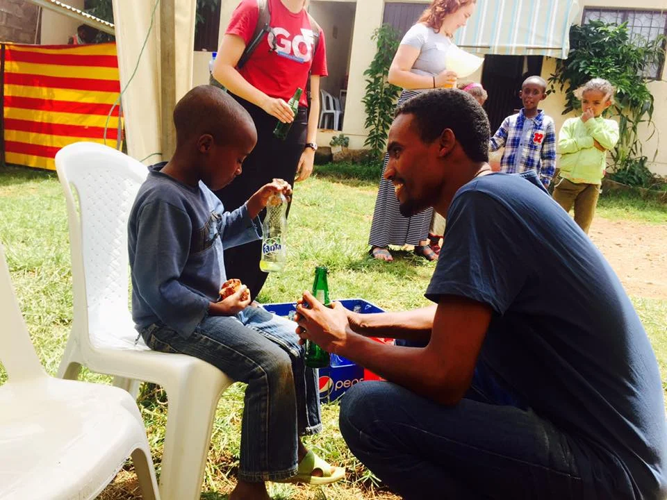 Nati enjoys a soda with a child at TLC's center. 