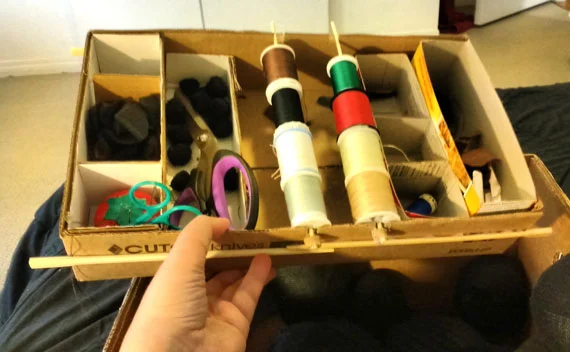 The top box is shallow and fit perfectly across the length of the bigger box but it needed a way to rest on the edge. Thanks to a friend's suggestion, I hot glued a few chopsticks as supports and they worked great.