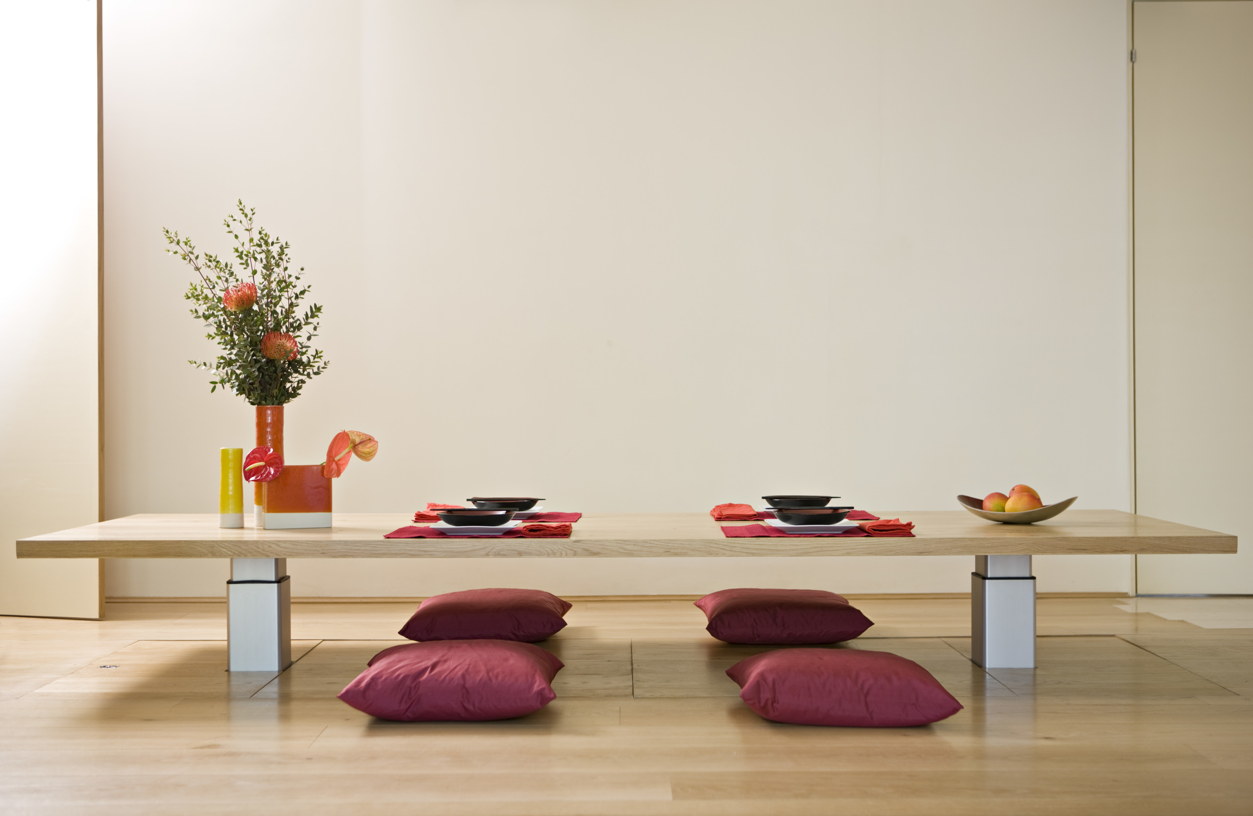 this kitchen was great fun. The client wanted to hide her kitchen away when not in use so I built a row of sliding folding doors with a space to display photographs set into each door. I used white lacquer for the doors, When the doors are open to reveal the working kitchen, a splash of vibrant Indus Red Zodiac work-top can be seen. 