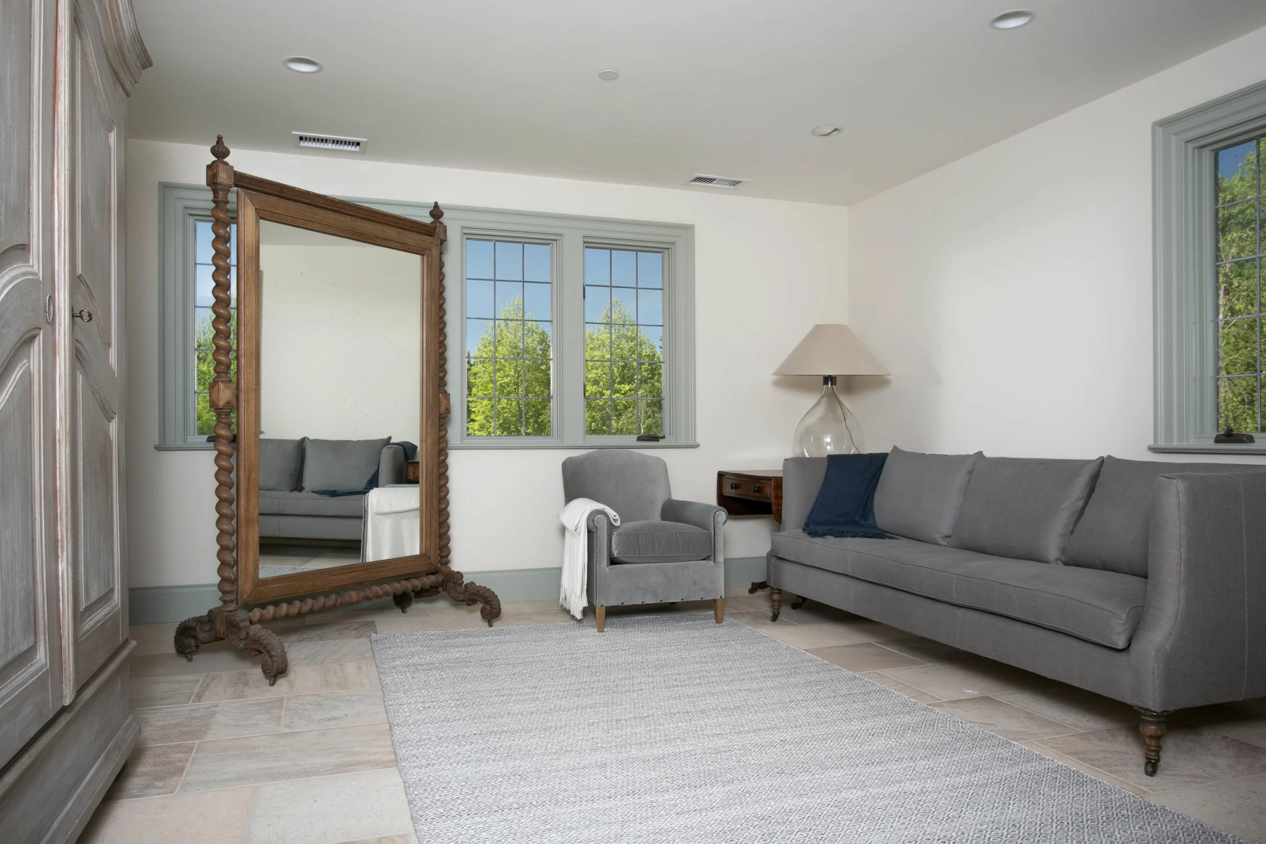 An antique French cheval mirror is the centerpiece in the living area of the guest house
