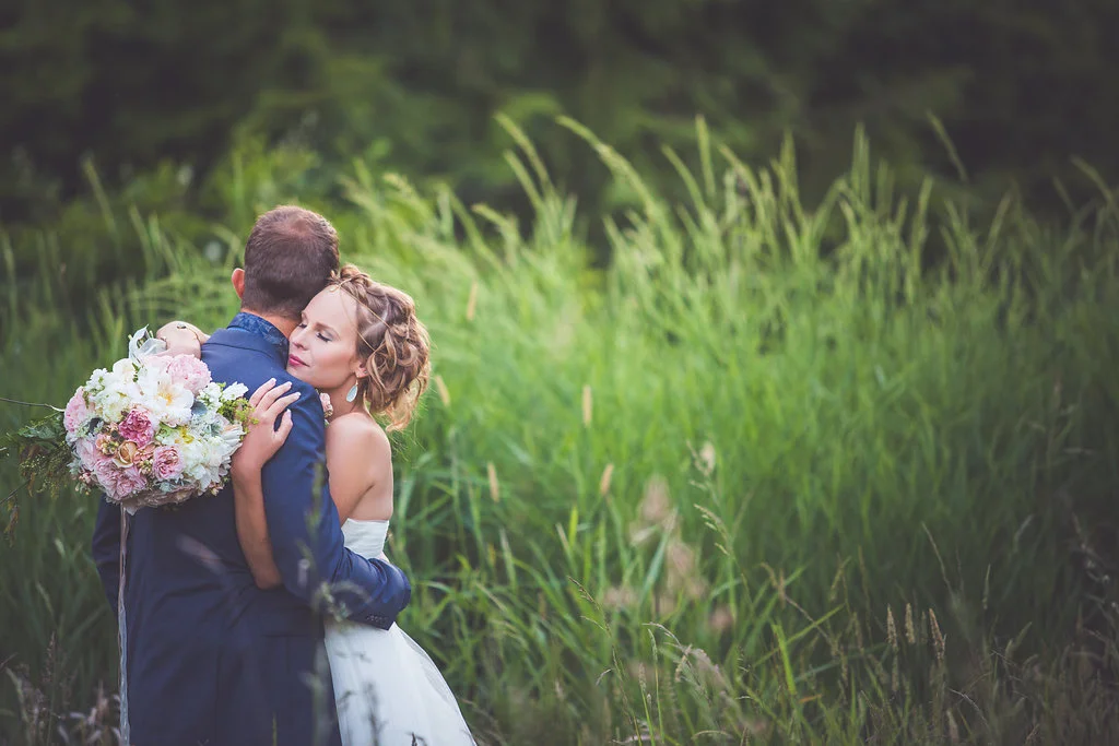 night song farms bouquet in brides hand as she hugs groom