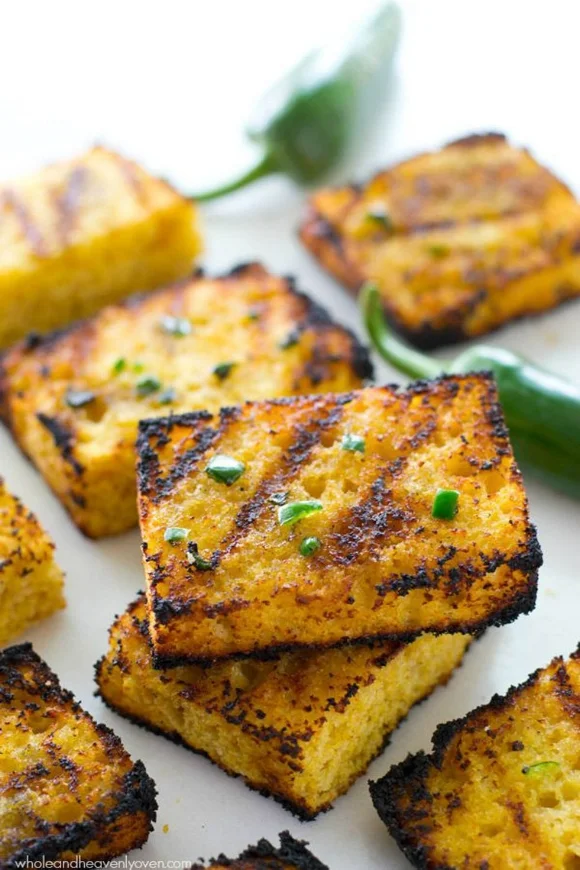 Soft, irresistible homemade cornbread squares are slathered up with a kickin’ jalapeno honey butter and then quickly cooked on the grill to crisp, buttery heaven!