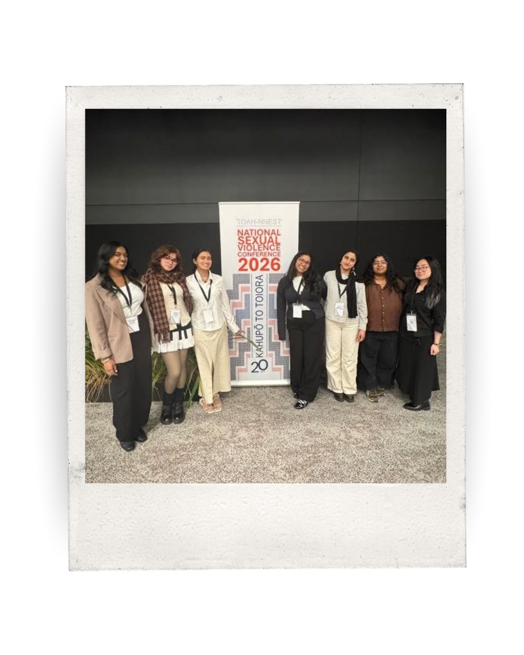 7 young people stand in front of the national sexual violence conference banner
