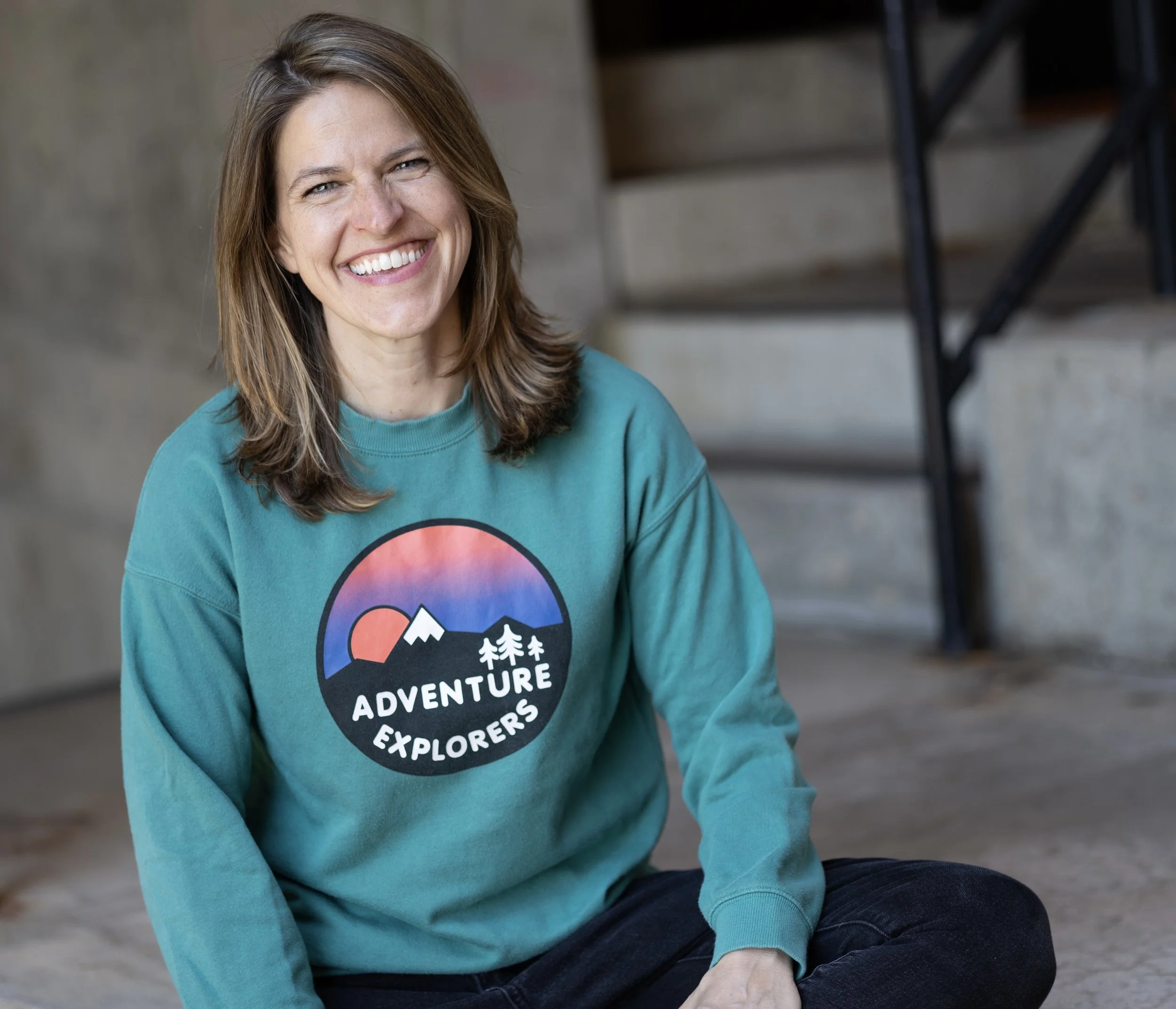 Susannah in a casual sweatshirt with the words "adventure explorers" across the chest.