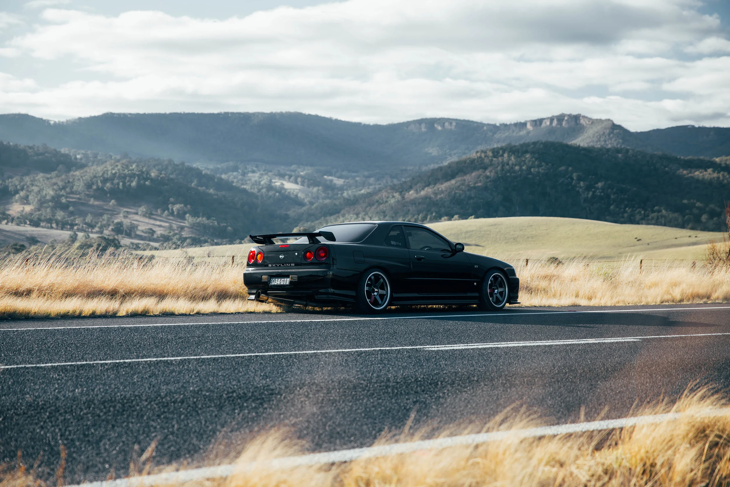 My R34 parked on the side of the road in Oberon for my Stay Driven look book. I can't get enough of the rolling mountains in the background.