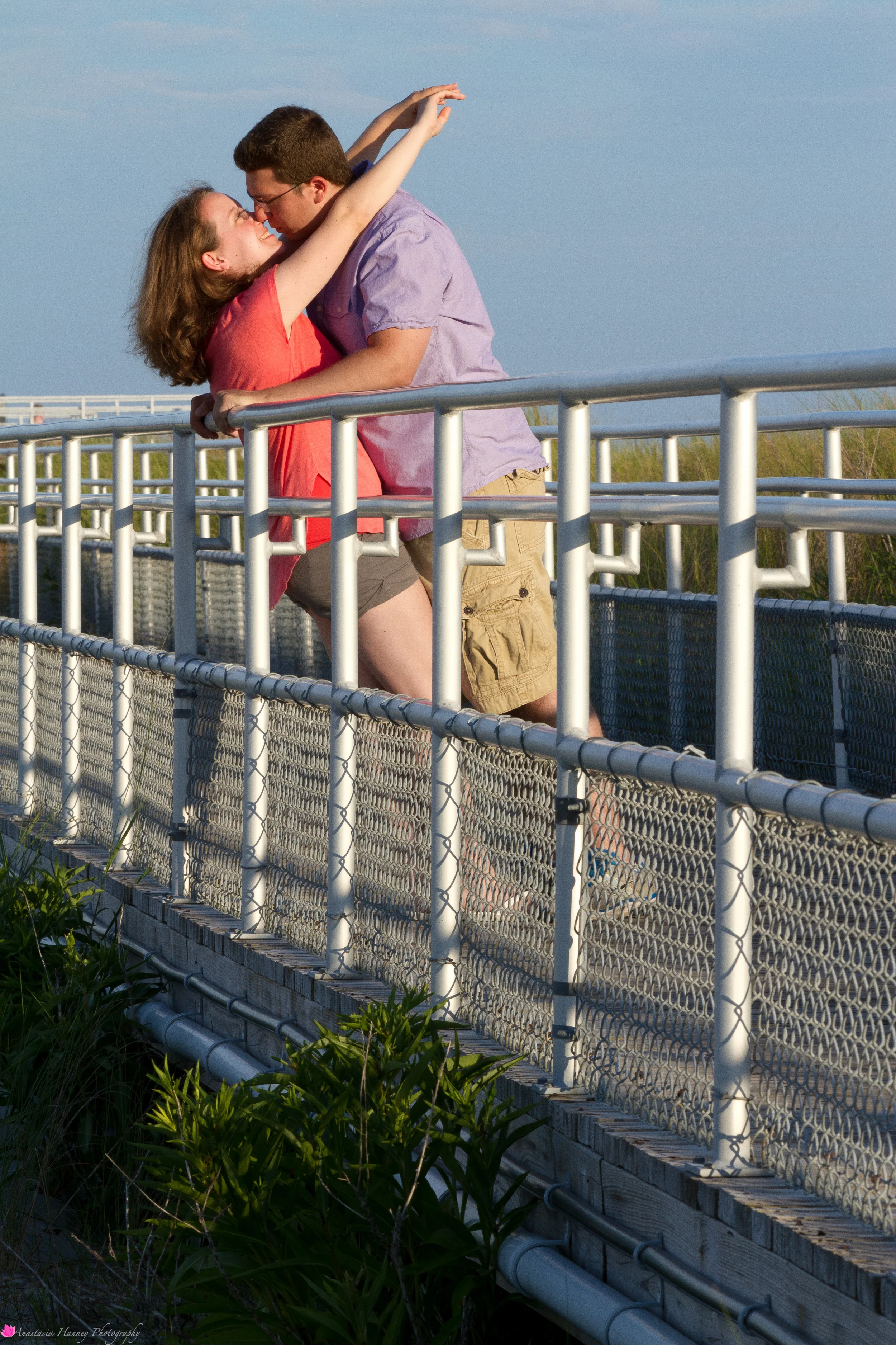 Engagement Photography Session of Couple on Boardwalk kissing by beach in Wildwood New Jersey Shore by Anastasia Hanney Photography
