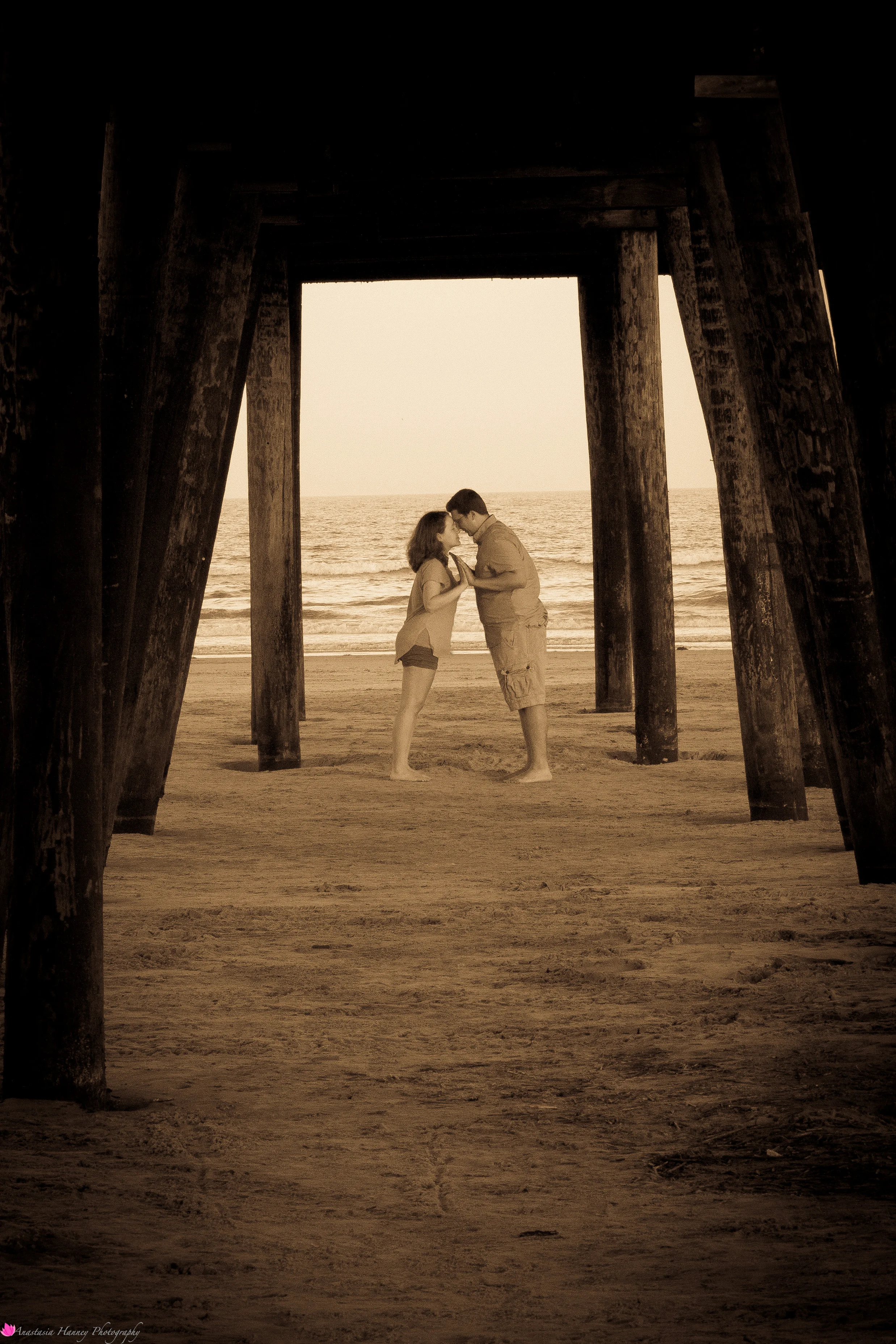 Engagement Photography Session of Couple on beach under the pier holding hands in Wildwood New Jersey Shore by Anastasia Hanney Photography