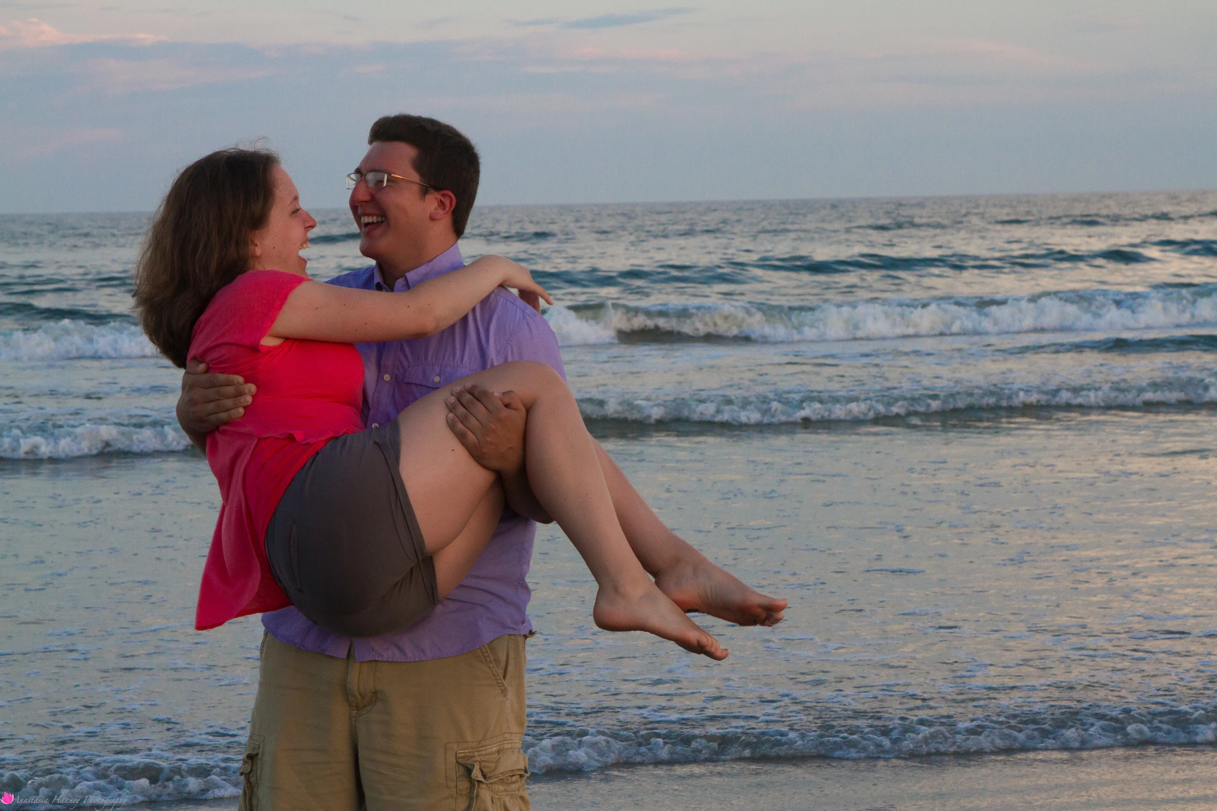 Engagement Photography Session of Couple on beach holding her close by ocean in Wildwood New Jersey Shore by Anastasia Hanney Photography