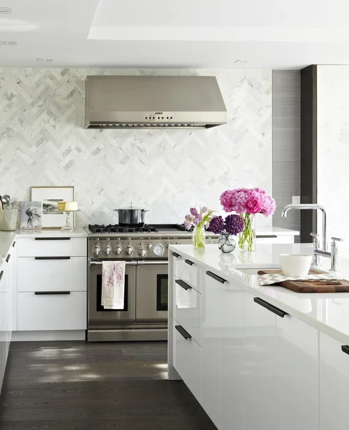 I love the larger scale tiles chosen for the herringbone patterned backsplash. Can you believe this is an IKEA kitchen? See more images below of the entire kitchen makeover. Design by: Croma Designs, Photos by: Virginia Macdonald